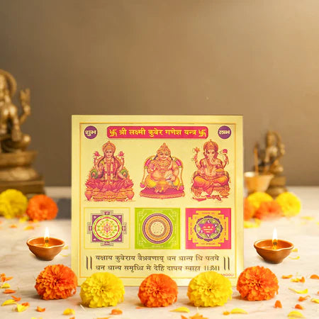 Hindu religious Yantra card featuring Shri Lakshmi, Kubera, and Ganesha surrounded by marigold flowers and oil lamps for worship