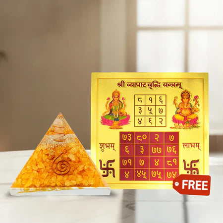Golden Shri Vyapar Vriddhi Yantra with Lakshmi and Ganesha images and orange pyramid energizer on white marble surface
